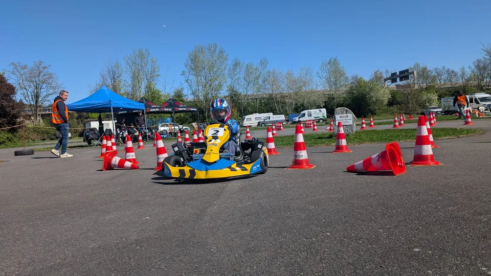 Slalomkart Nummer 2 im Pylonenfeld, Zuschauer unter Pavillons