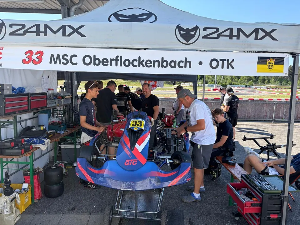 Die Mannschaft arbeitet unter dem MSC-Boxenzelt am blauen Kart mit der Startnummer 33