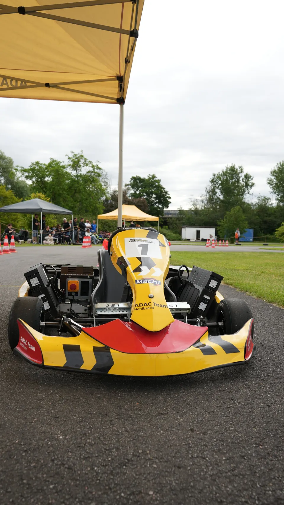 Elektrokart mit Startnummer 1 unter einem Zelt vor dem Lauf