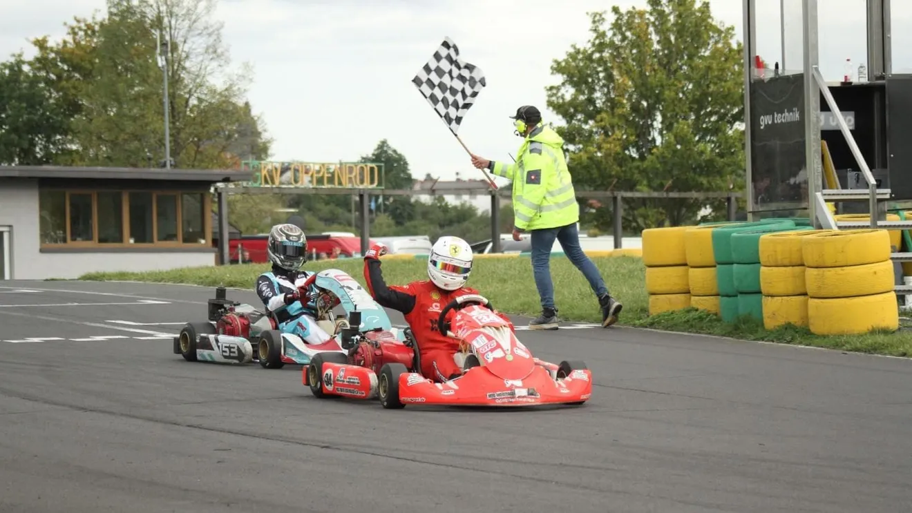 Karts auf der Strecke unter der geschwenkten Zielflagge