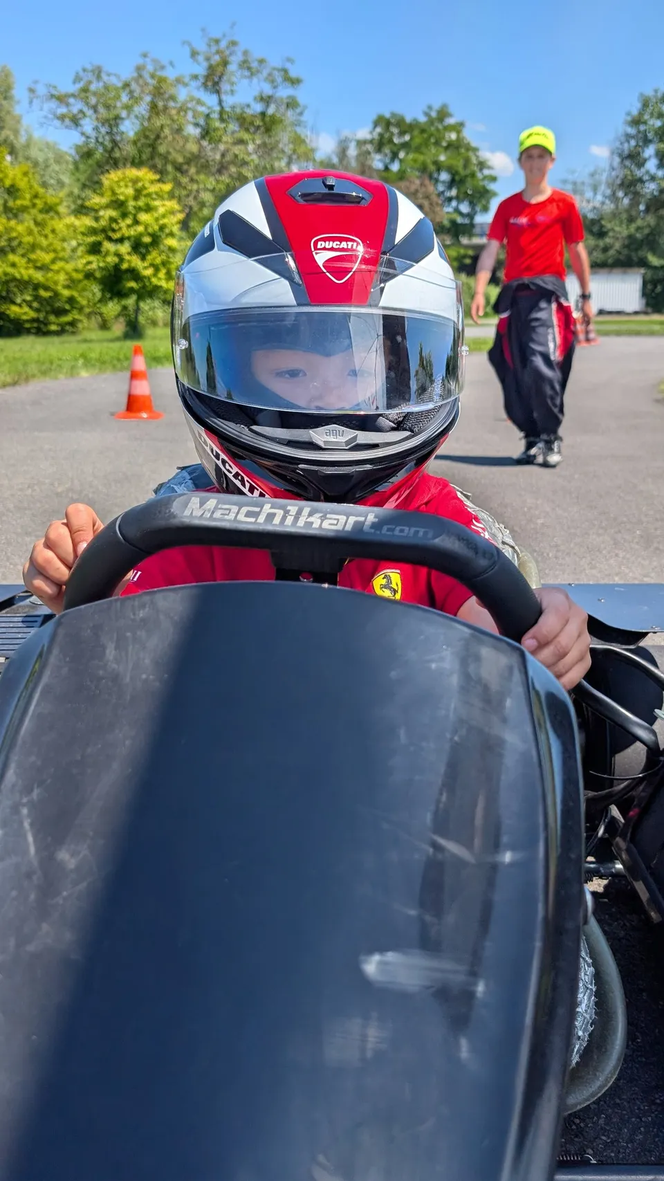 Junger Fahrer mit Helm am Lenkrad des Elektrokarts