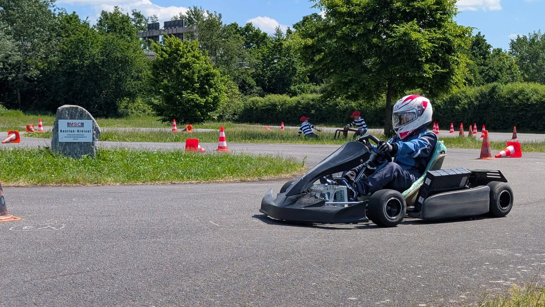 Jugendlicher im Kart zwischen roten Pylonen auf dem Vereinsplatz