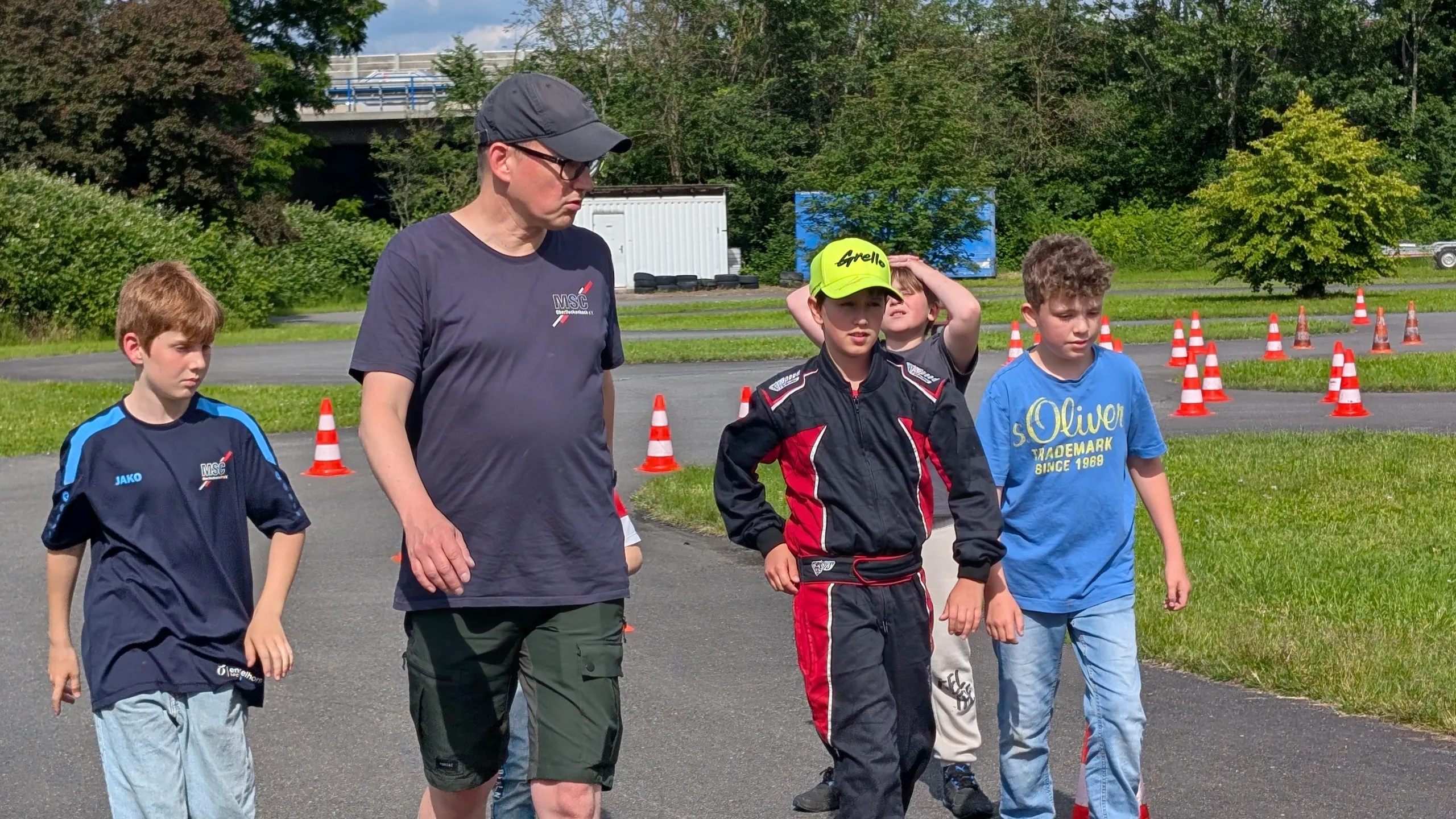 Ein Trainer und Kinder besprechen den Parcours auf dem Vereinsplatz.
