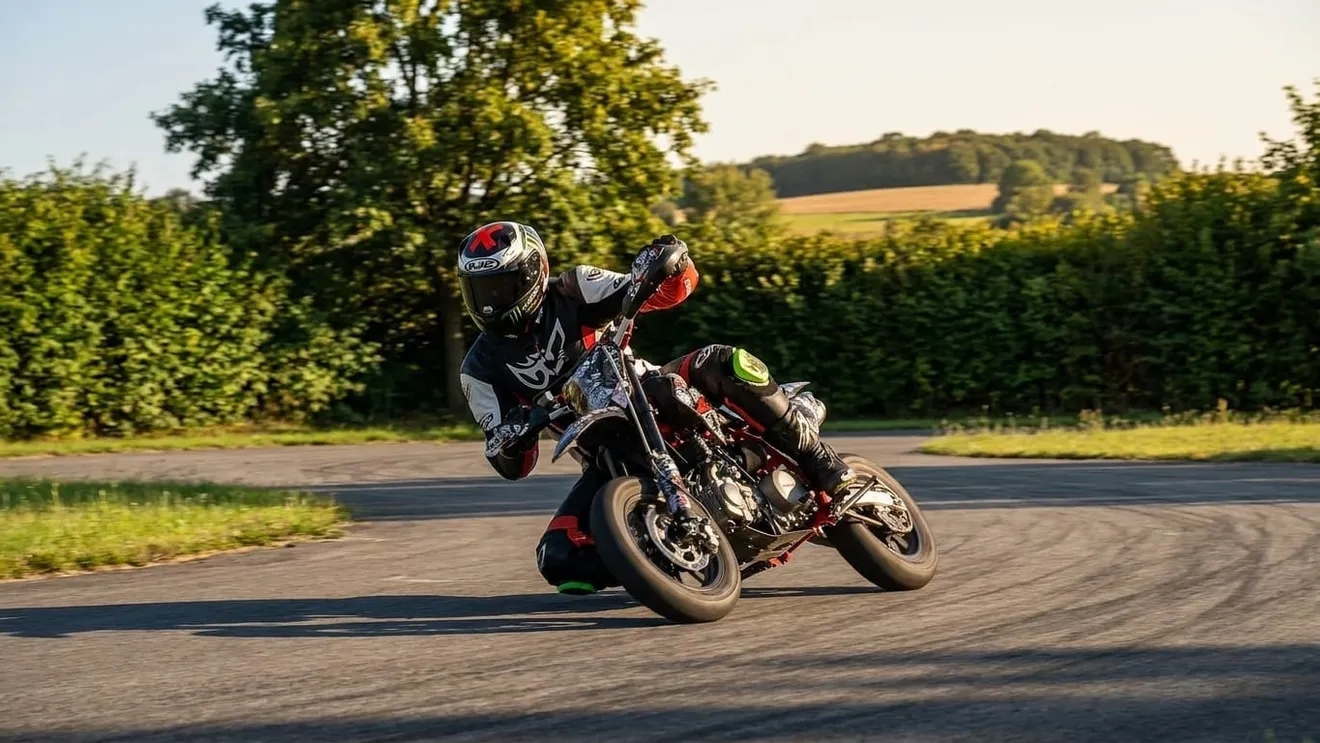 Pitbike-Fahrer legt sich mit dem Knie nahe am Asphalt in die Kurve