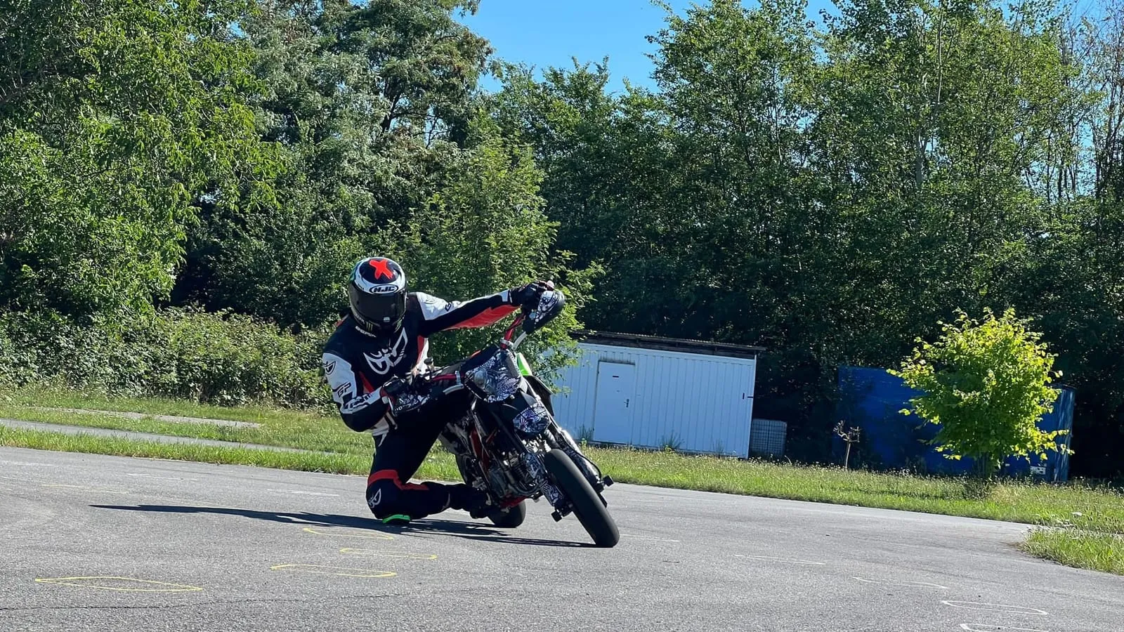 Pitbike-Fahrer in Schräglage auf dem Vereinsplatz