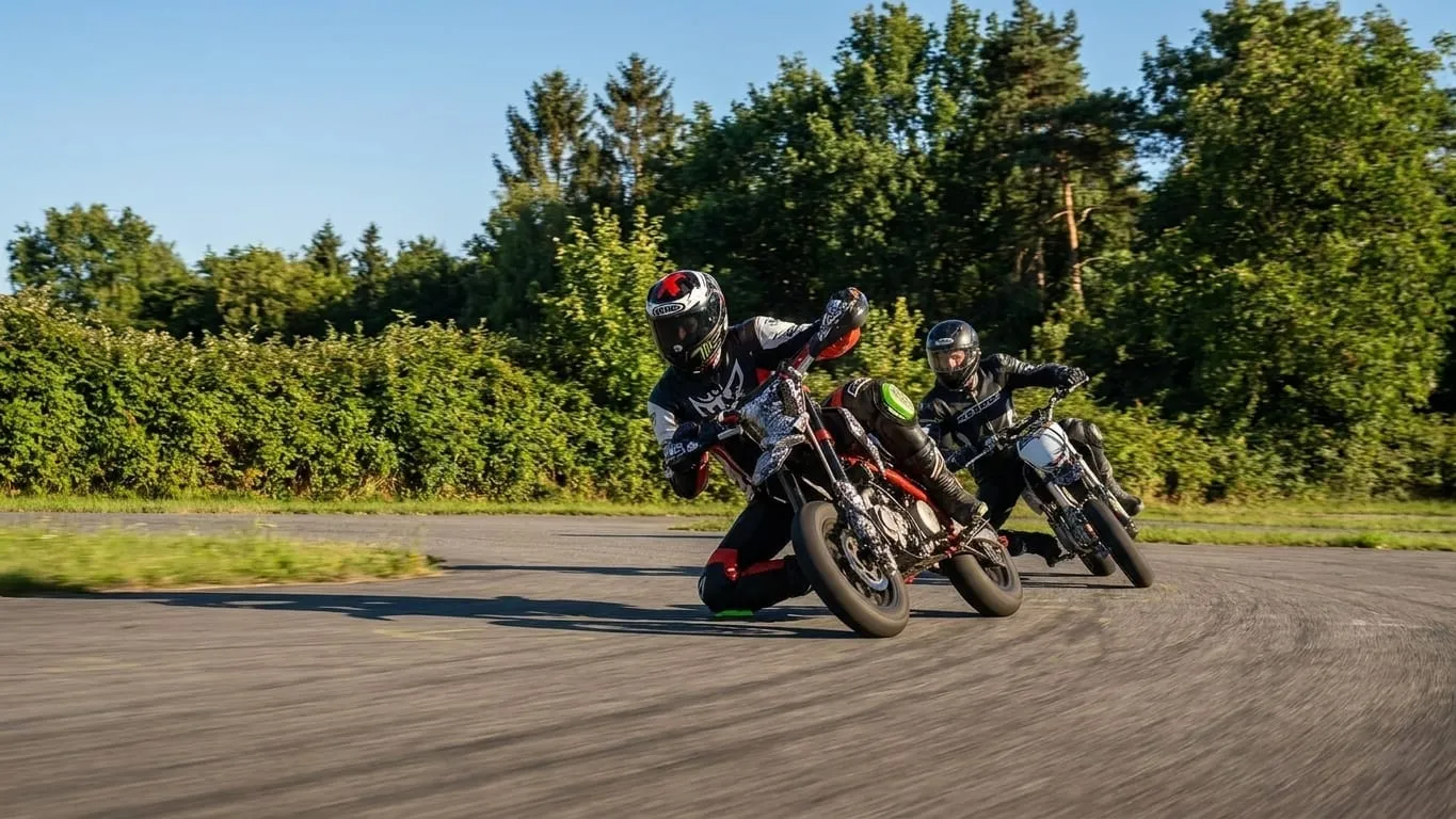 Zwei Pitbike-Fahrer hintereinander in einer Kurve auf dem Vereinsplatz
