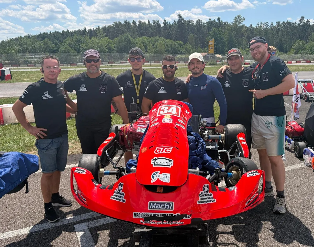 Das Team der Nummer 34 mit seinem roten Kart an der Strecke